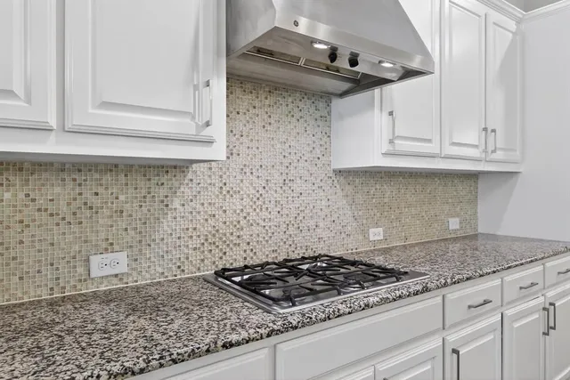 a kitchen with granite countertop a stove sink and cabinets