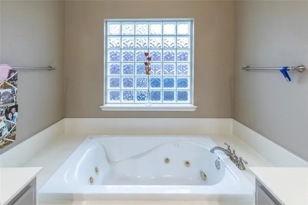 a white bath tub sitting in a bathroom next to a window