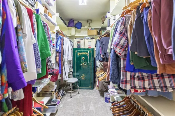 a view of walk in closet with clothes and shoes