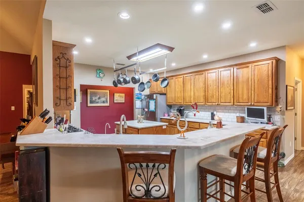 a kitchen with a sink stove and chairs