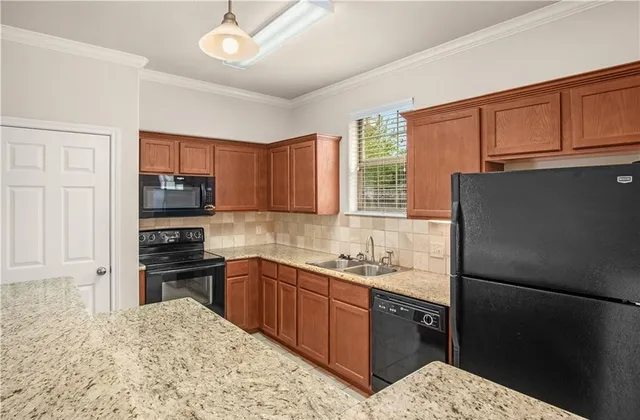 a kitchen with a sink a refrigerator and cabinets