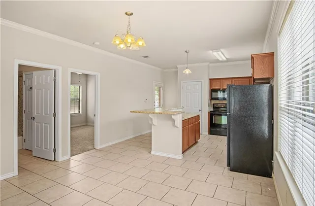 a kitchen with stainless steel appliances kitchen island granite countertop a refrigerator and a sink