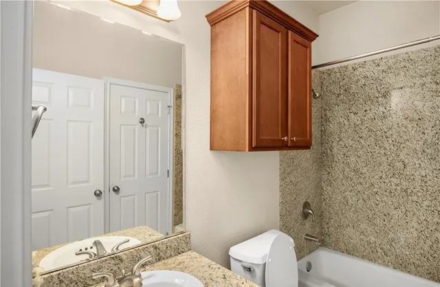 a bathroom with a toilet a sink and shower