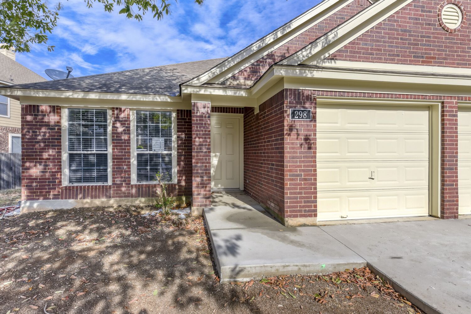 298 Fall Drive Kyle, TX 78640 - Photo 20 of 23 Property entrance with brick siding, roof with shingles, a garage, and driveway