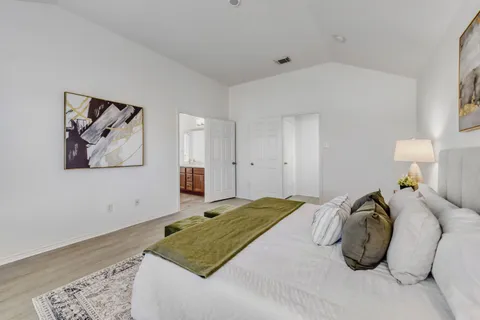 a bedroom with a bed and a painting on the wall