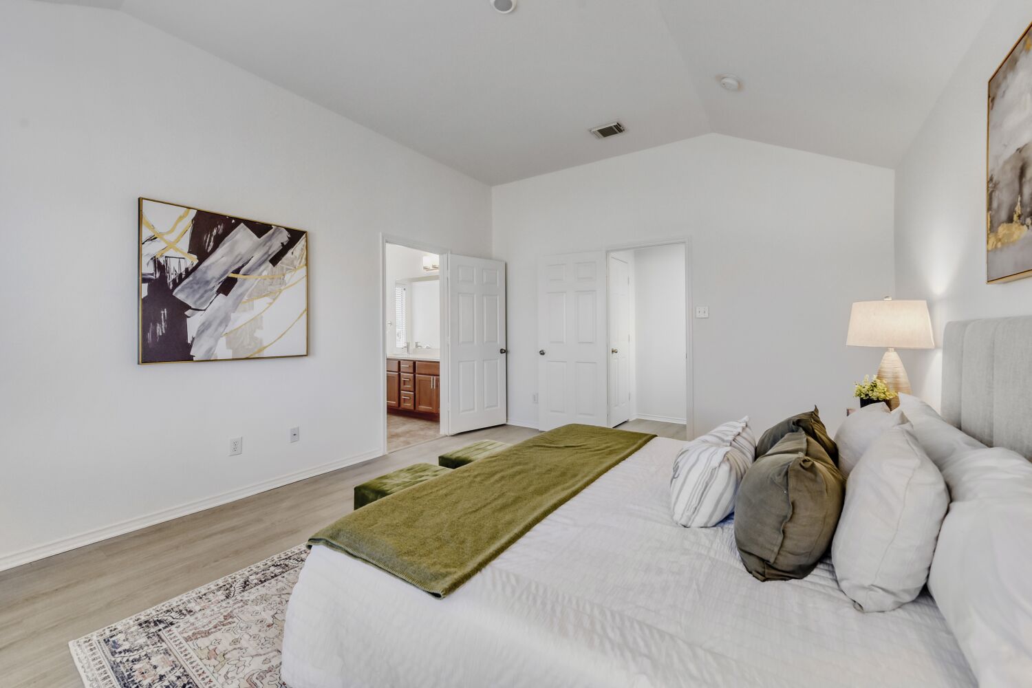 298 Fall Drive Kyle, TX 78640 - Photo 8 of 23 Bedroom with vaulted ceiling, en suite bathroom, and wood finished floors