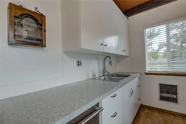 a kitchen with granite countertop a sink a stove and cabinets