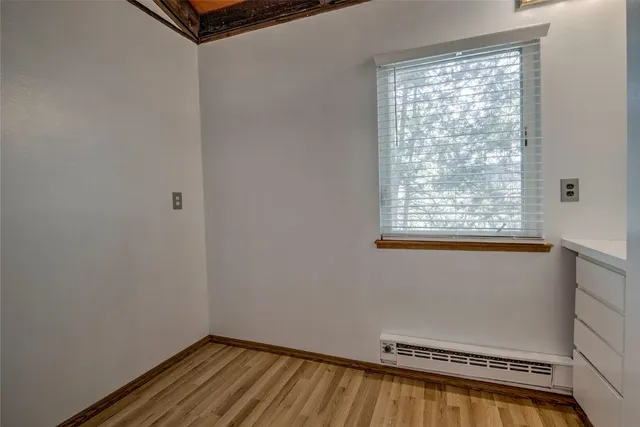 a view of a room with wooden floor and a window