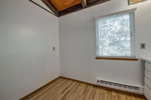 a view of a room with wooden floor and a window