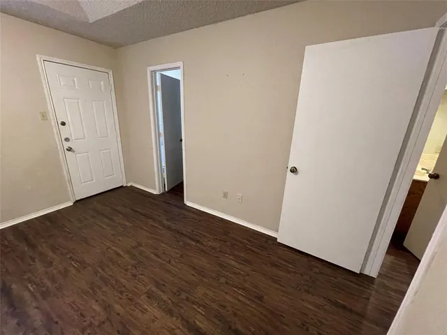 an empty room with wooden floor and closet