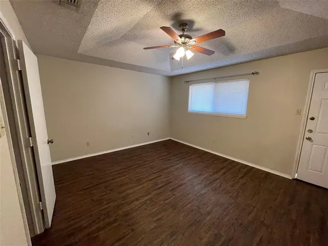 an empty room with wooden floor and chandelier fan