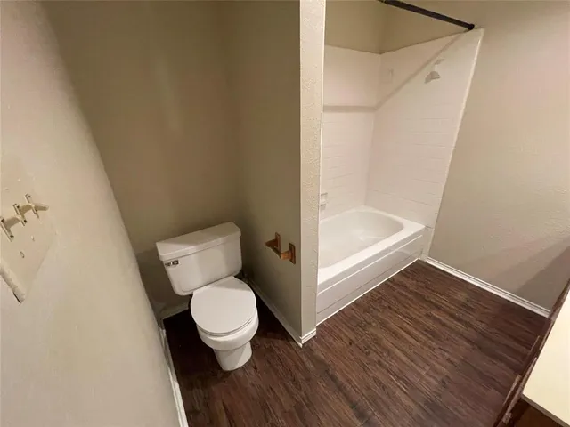 a white toilet sitting in a bathroom next to a sink