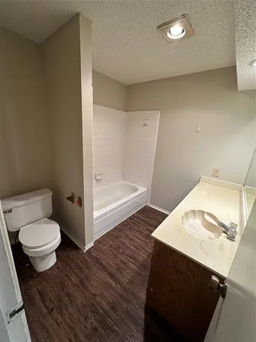an empty room with wooden floor ceiling fan and window