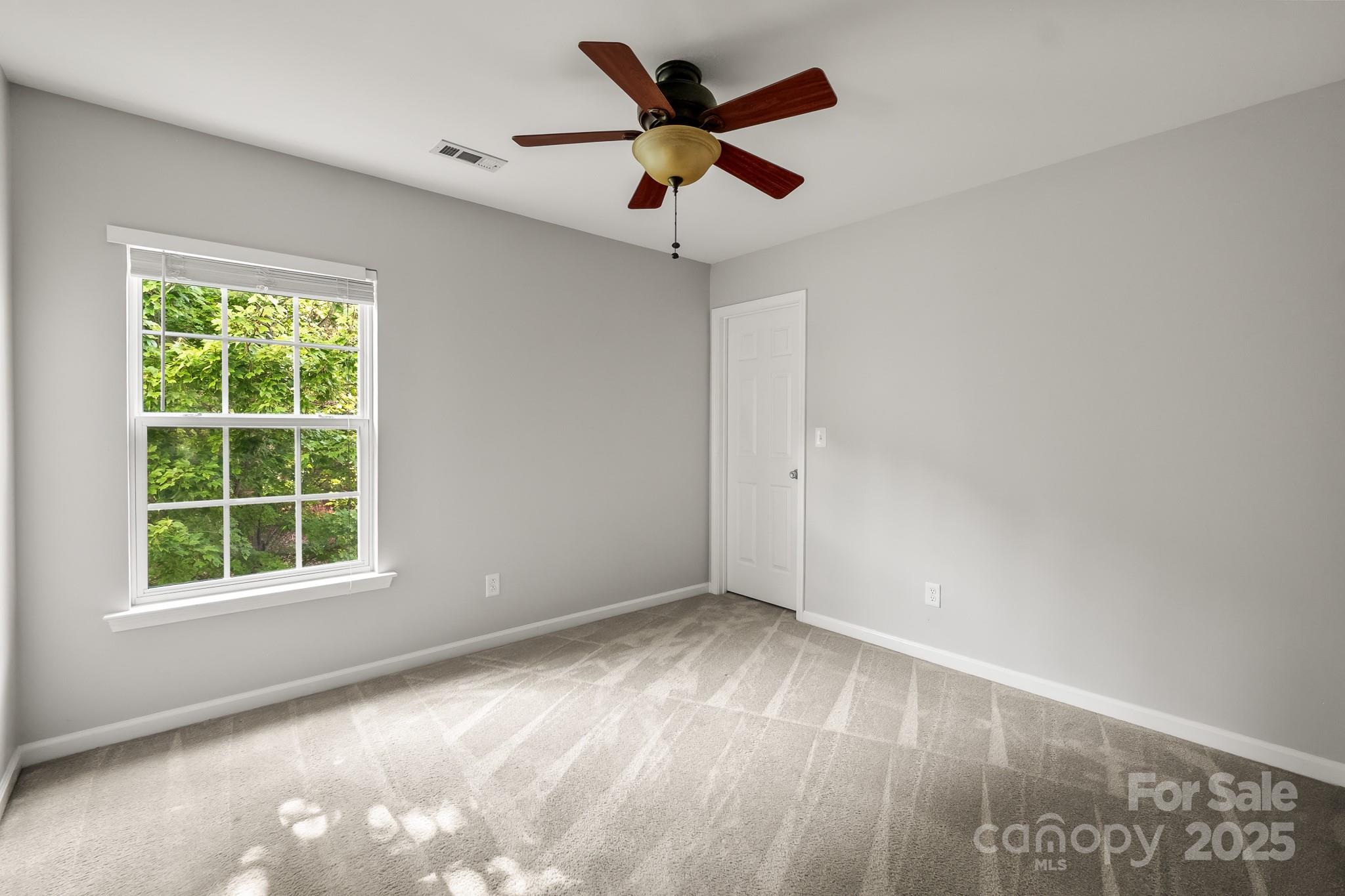 9607 Seamill Road Charlotte, NC 28278 - Photo 15 of 18 an empty room with window and a ceiling fan
