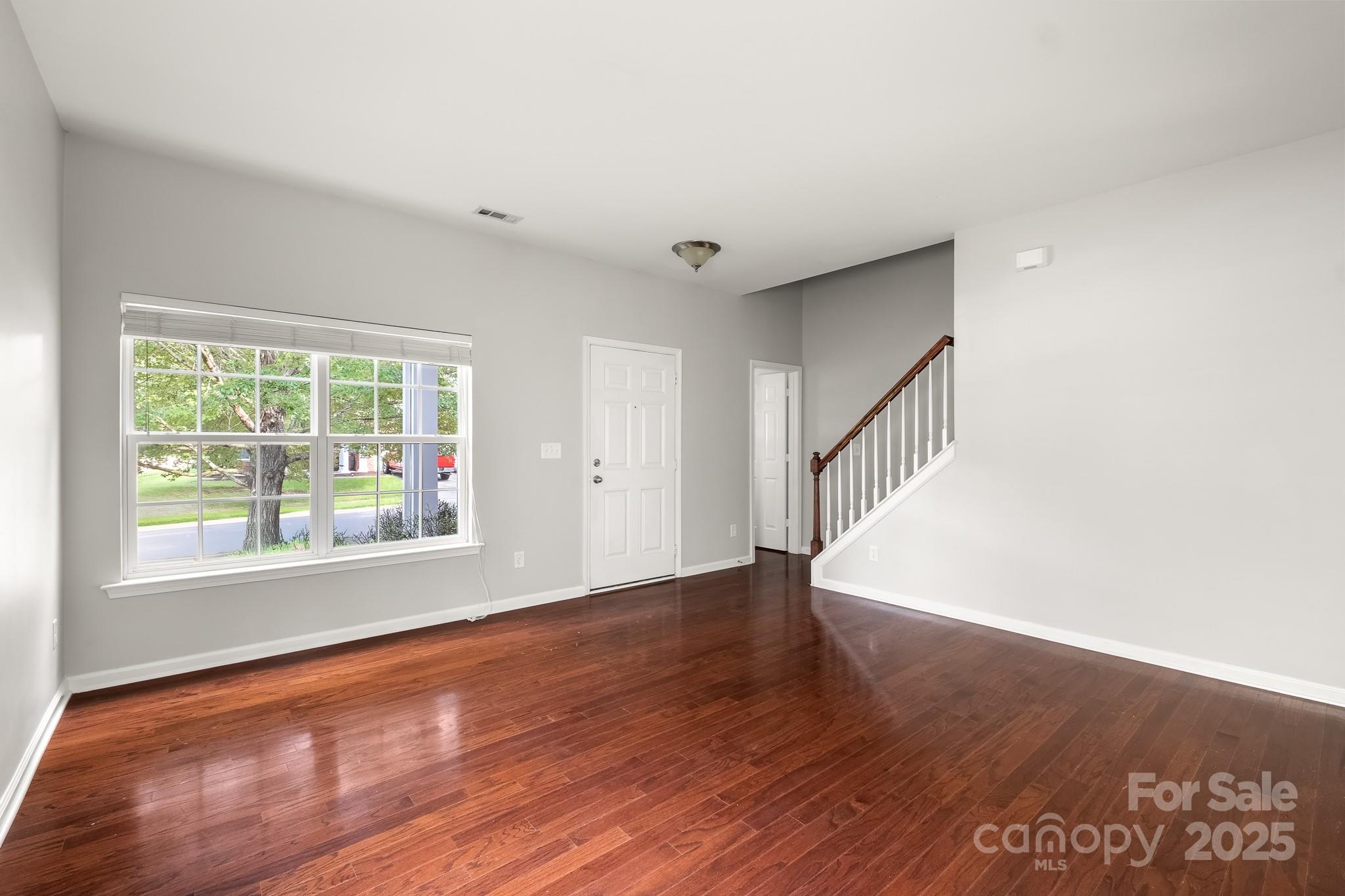 9607 Seamill Road Charlotte, NC 28278 - Photo 3 of 18 a view of an empty room with wooden floor and a window