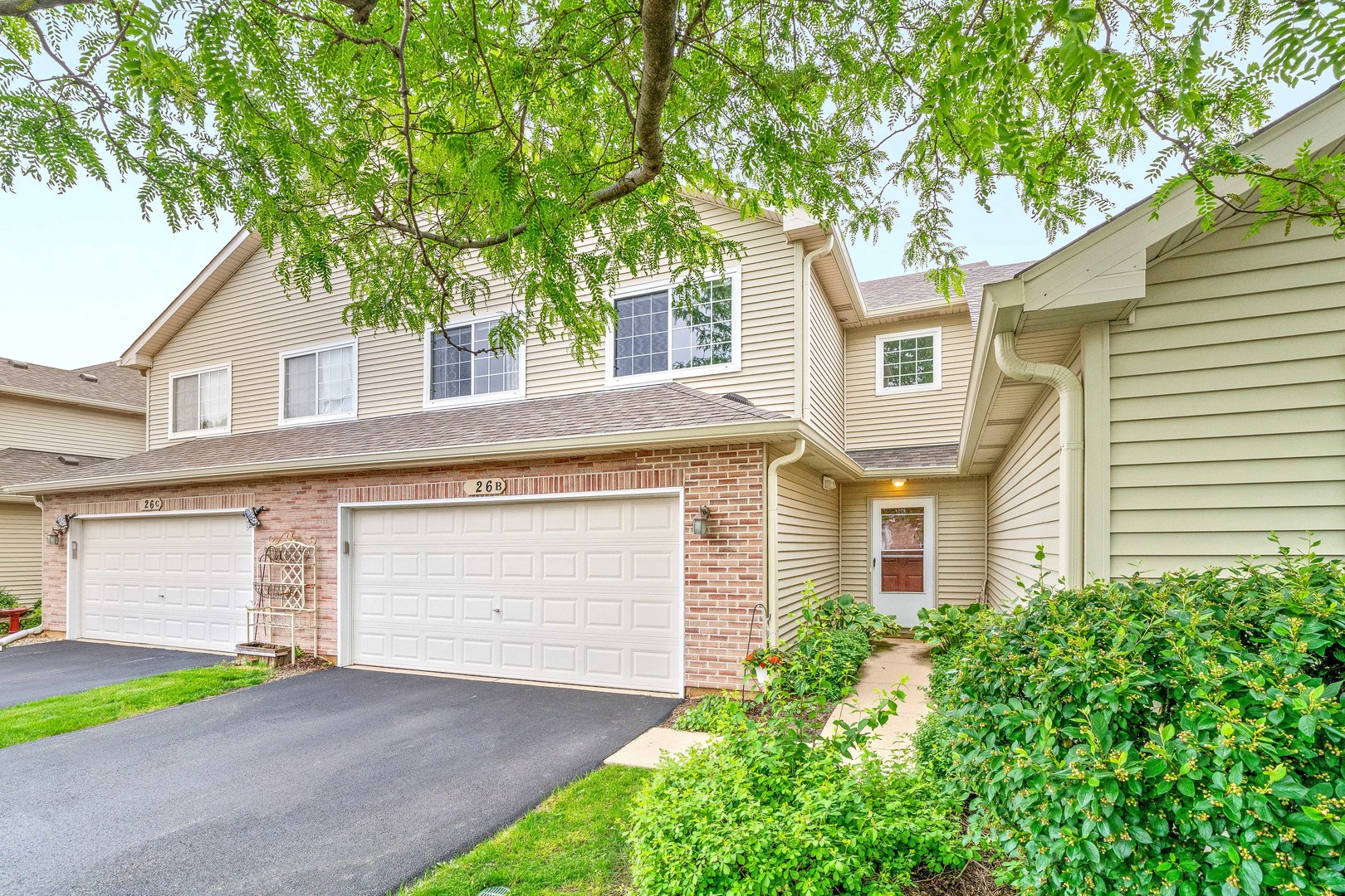 26 Rolling Oaks Road, Unit B Sugar Grove, IL 60554 - Photo 2 of 17 a front view of a house with a yard and garage