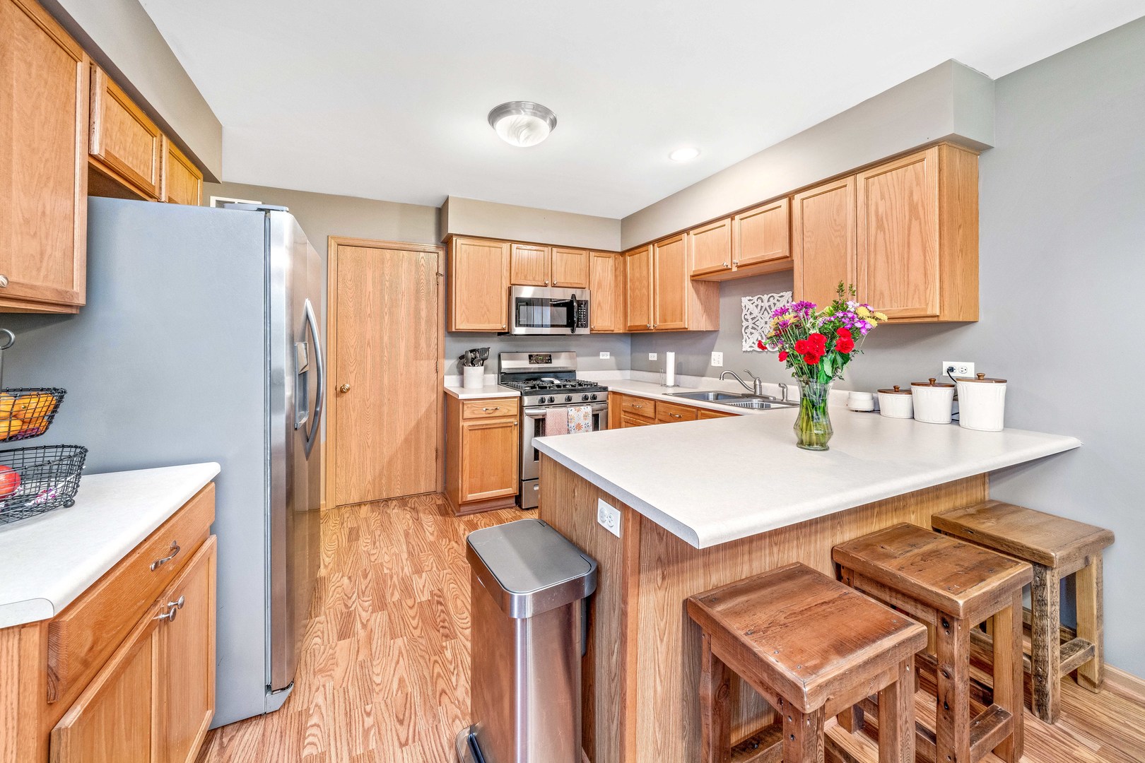 26 Rolling Oaks Road, Unit B Sugar Grove, IL 60554 - Photo 7 of 17 a kitchen with a refrigerator a stove a sink dishwasher and a dining table with wooden floor