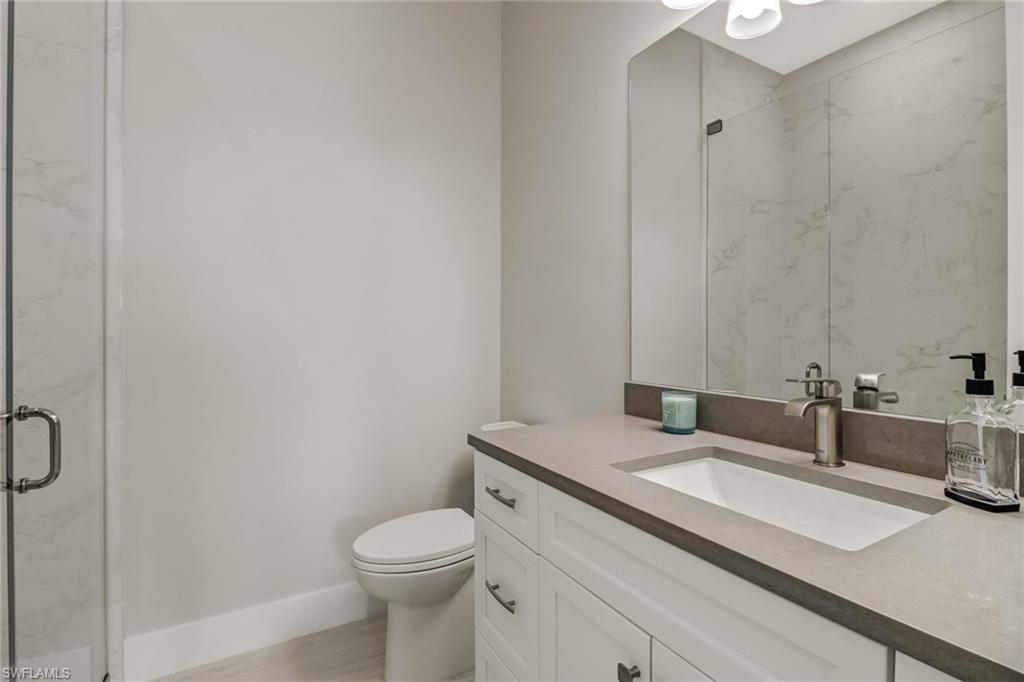 1395 Curlew Avenue, Unit 43 Naples, FL 34102 - Photo 15 of 31 a bathroom with a granite countertop sink a toilet and a mirror