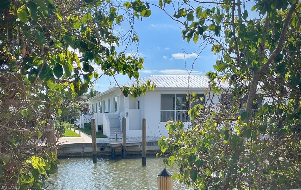 1395 Curlew Avenue, Unit 43 Naples, FL 34102 - Photo 29 of 31 a house with trees in front of it