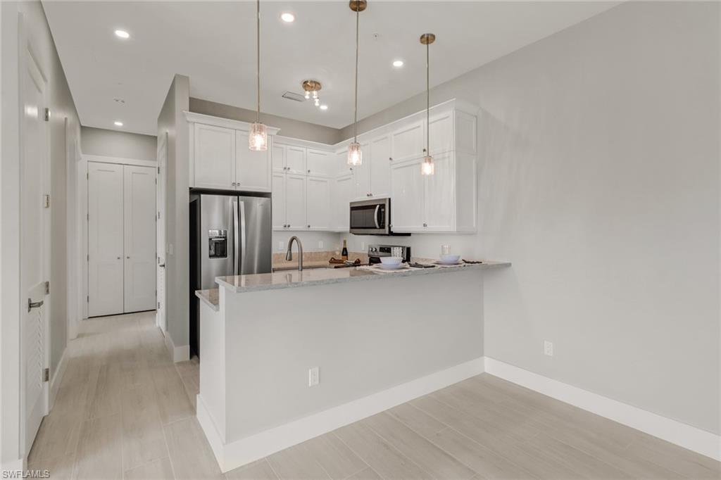 1395 Curlew Avenue, Unit 43 Naples, FL 34102 - Photo 8 of 31 an open kitchen with cabinets and stainless steel appliances