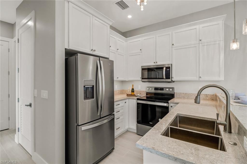 1395 Curlew Avenue, Unit 43 Naples, FL 34102 - Photo 10 of 31 a kitchen with granite countertop a refrigerator stove and microwave