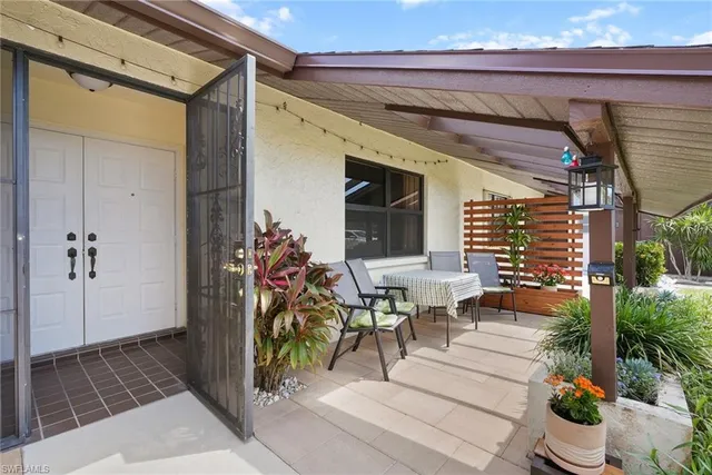 a view of a porch with chairs and potted plants