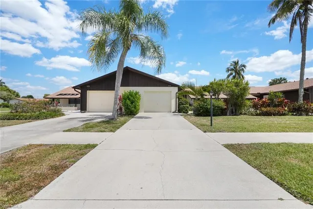 a front view of a house with a yard and potted plants