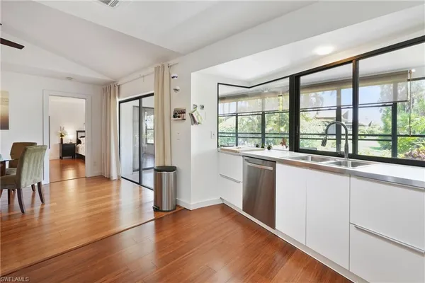 a open kitchen with granite countertop a refrigerator and wooden floor