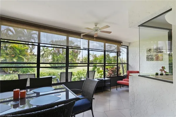 a living room with furniture and floor to ceiling windows