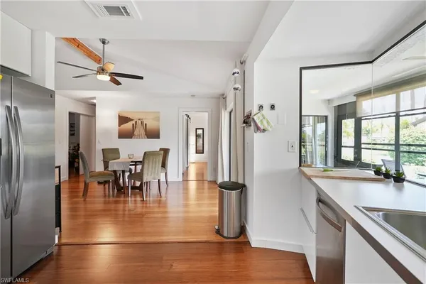 a view of a dining room with furniture a chandelier and wooden floor