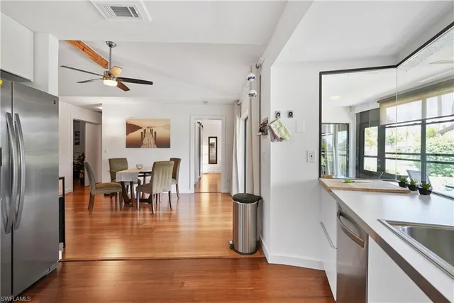 a view of a dining room with furniture a chandelier and wooden floor