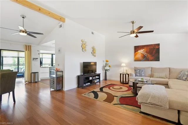 a living room with furniture a flat screen tv and a window