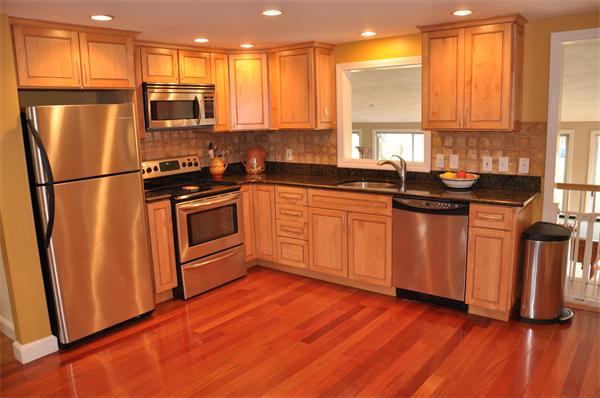 54 Nancy Road Concord, MA 01742 - Photo 3 of 16 a kitchen with stainless steel appliances granite countertop a refrigerator a sink dishwasher and wooden cabinets with wooden floor