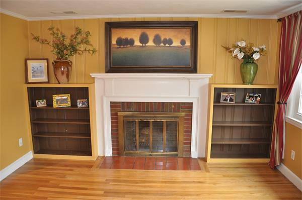 54 Nancy Road Concord, MA 01742 - Photo 7 of 16 a view of a livingroom with a fireplace a ceiling fan and wooden floor