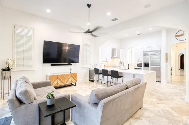 a living room with furniture kitchen view and a wooden floor