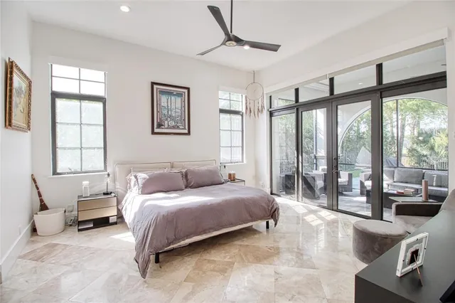 a bedroom with a bed couch and large window