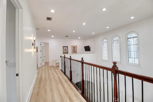 a spacious bedroom with a bed a mirror and a large window