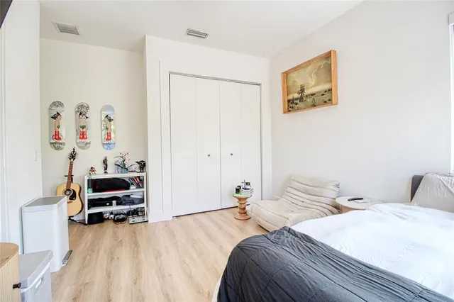 a bedroom with a bed a couch and a painting on the wall