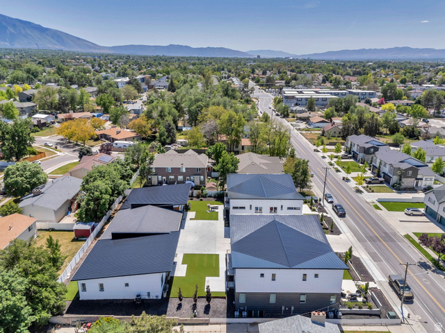 7045 South 300 East Midvale, UT 84047 - Photo 42 of 49 Modern architectural design featuring white and dark gray facades, dark metal roofs, paved parking areas, and artificial turf landscaping