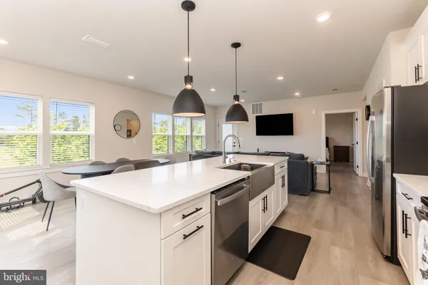 a kitchen with stainless steel appliances granite countertop a sink a stove and a refrigerator