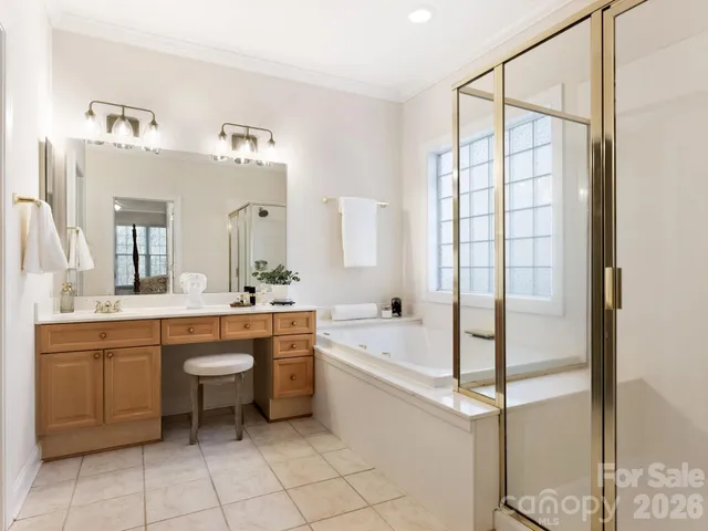 a spacious bathroom with a double vanity sink a mirror and a bathtub