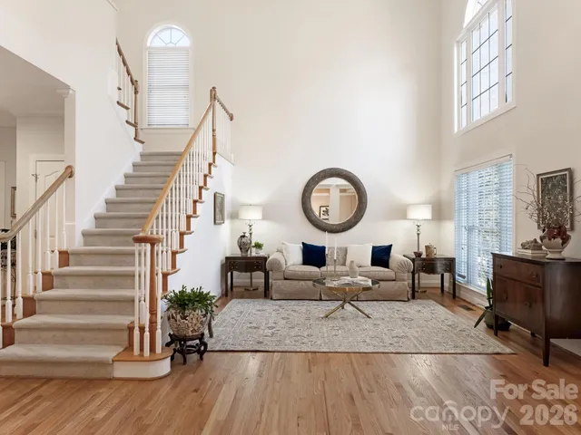 a living room with furniture kitchen view and a large window
