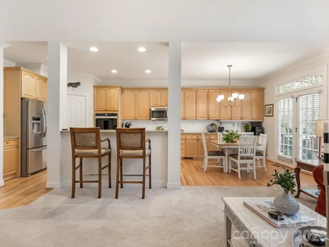 a view of a kitchen with kitchen island dining table and stainless steel appliances