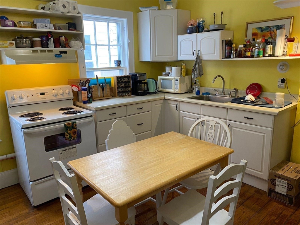 a kitchen with a table chairs stove and sink