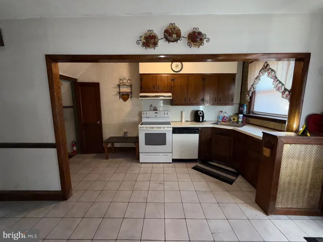 a kitchen with stainless steel appliances a sink cabinets and wooden floor