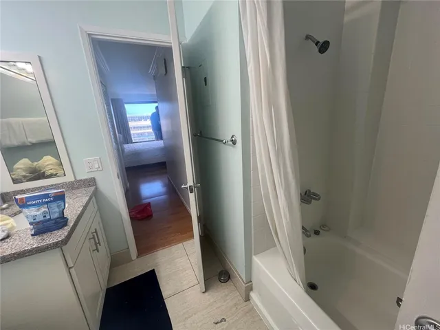 a bathroom with a tub shower and sink