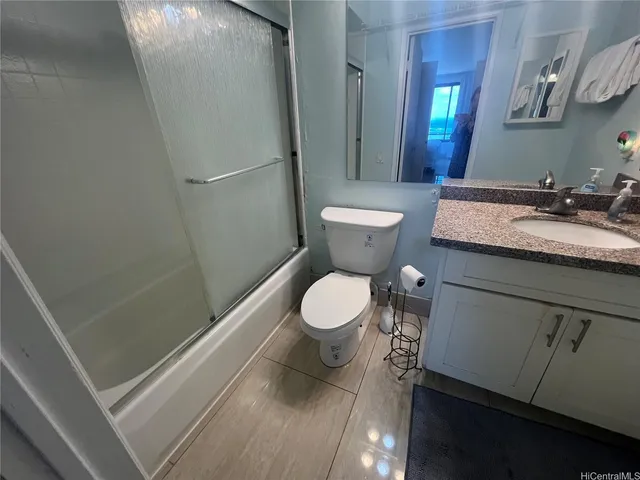a bathroom with a granite countertop sink toilet a mirror and shower