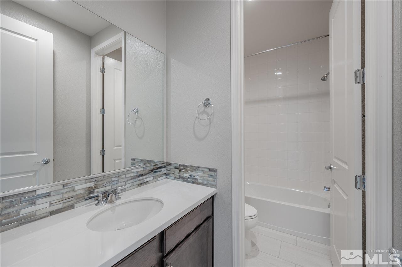 3035 Country Wind Lane, Unit HOMESITE 72 Reno, NV 89521 - Photo 13 of 15 a bathroom with a granite countertop sink a toilet and shower