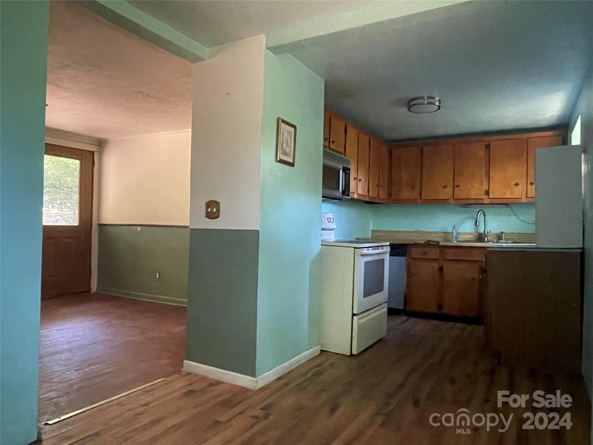 77 Medford Road Tryon, NC 28782 - Photo 29 of 48 a kitchen with granite countertop wooden cabinets and white appliances