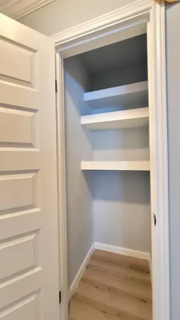 a view of walk in closet with empty racks